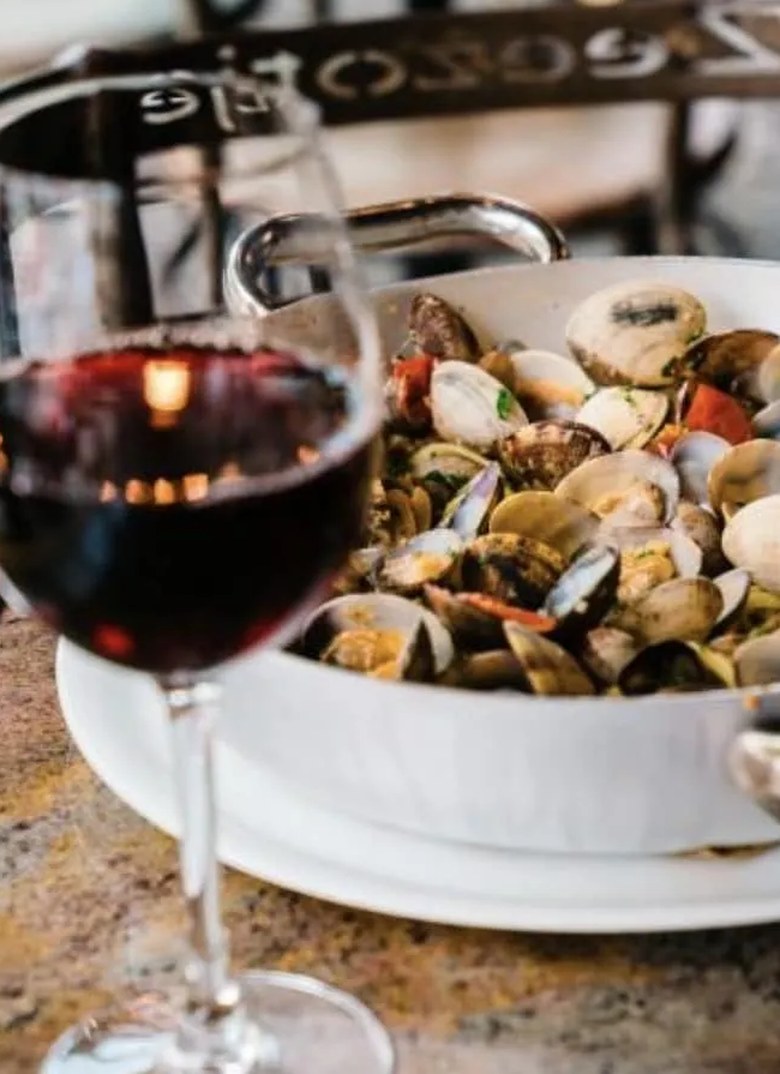 Tagliolini alle vongole met een glas rode wijn op tafel bij 't Zeezotje